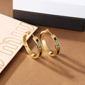 MIUMIU 26S LOGO HOOP EARRINGS IN BLACK ENAMEL AND GOLD TONE METAL 626893