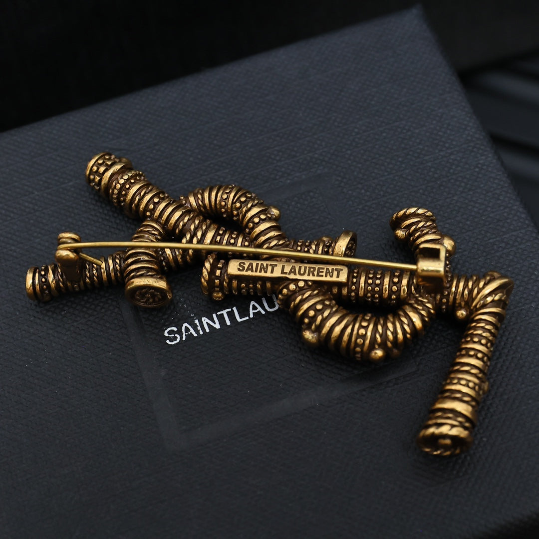 YSL 26S ORNATE TEXTURED MONOGRAM BROOCH IN ANTIQUE GOLD TONE METAL 617587