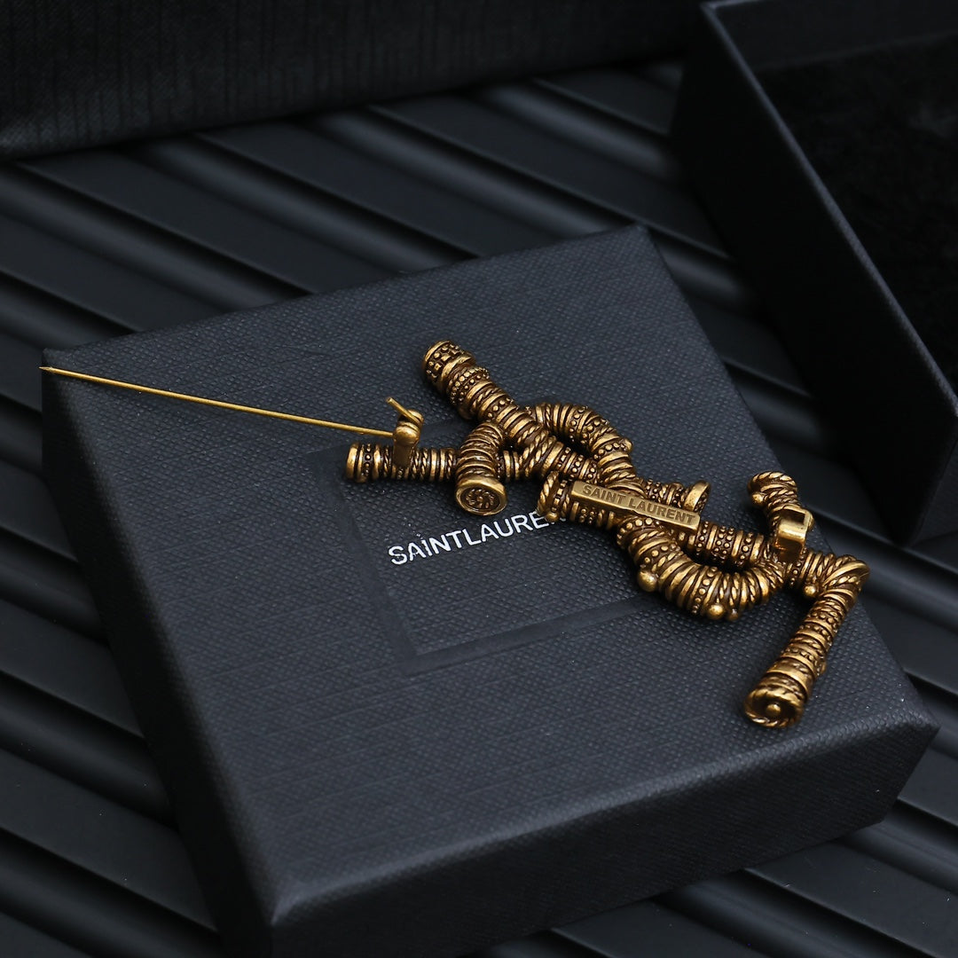 YSL 26S ORNATE TEXTURED MONOGRAM BROOCH IN ANTIQUE GOLD TONE METAL 617587
