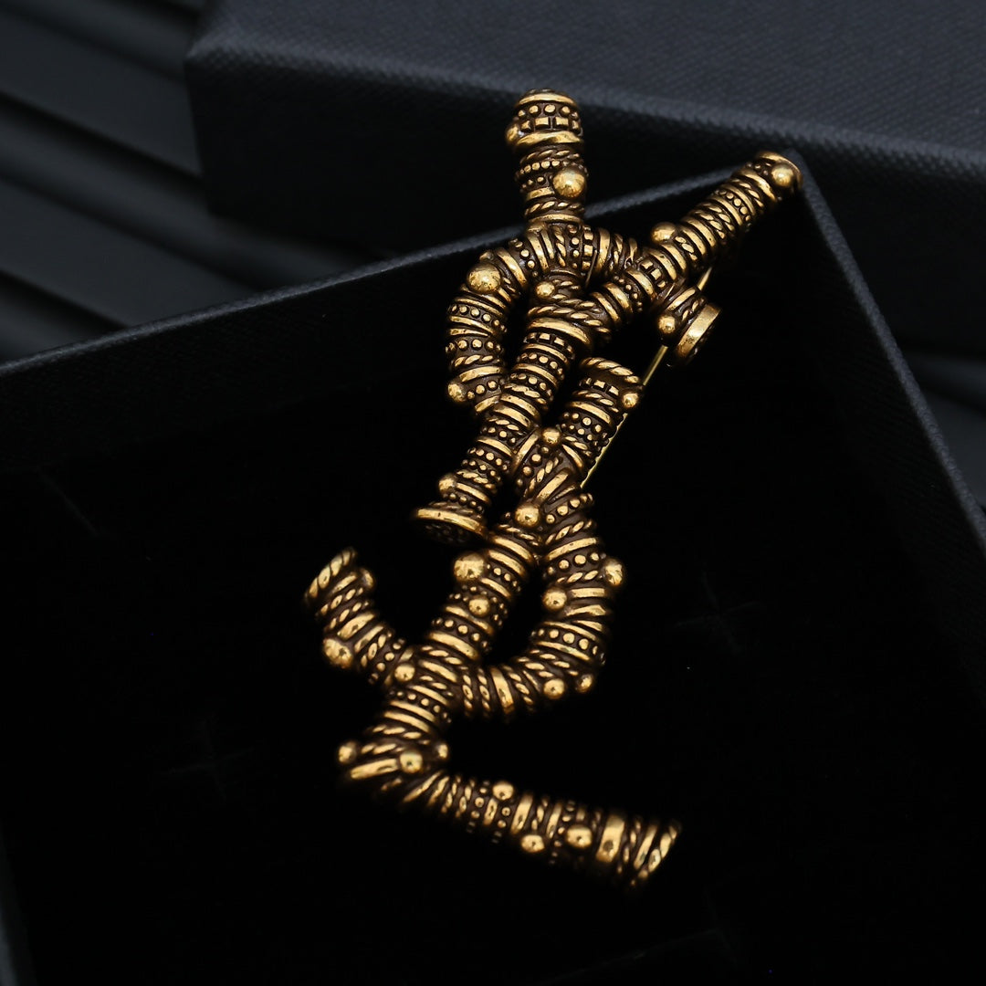 YSL 26S ORNATE TEXTURED MONOGRAM BROOCH IN ANTIQUE GOLD TONE METAL 617587