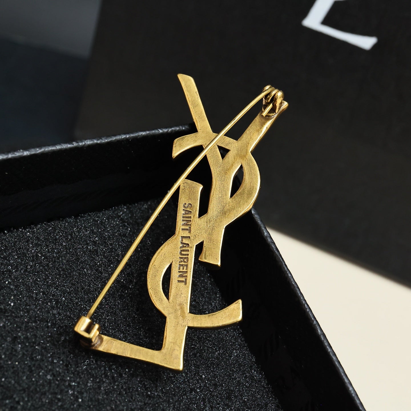 YSL 26S TEXTURED MONOGRAM BROOCH IN ANTIQUE GOLD TONE METAL