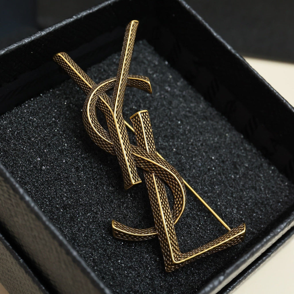 YSL 26S TEXTURED MONOGRAM BROOCH IN ANTIQUE GOLD TONE METAL