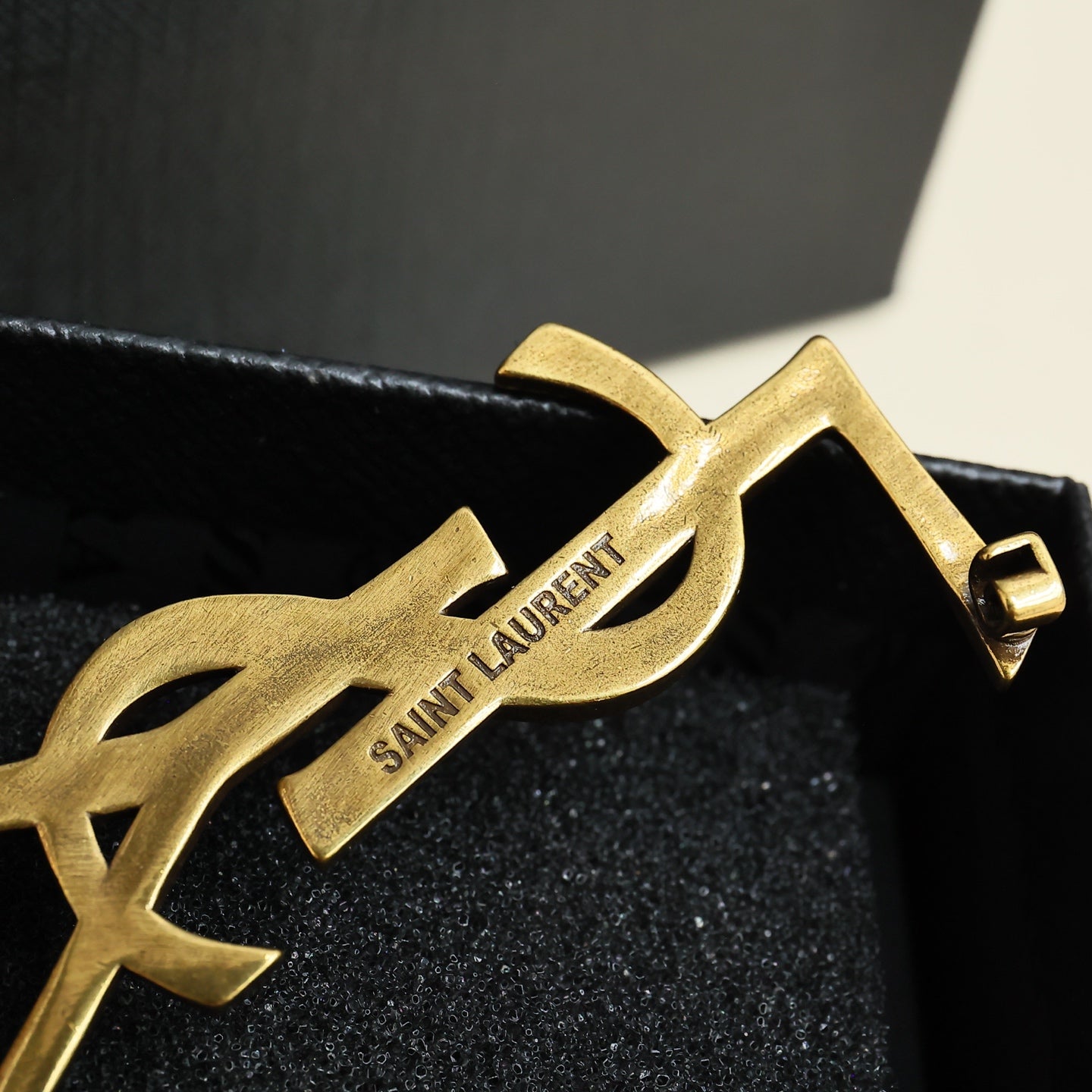 YSL 26S TEXTURED MONOGRAM BROOCH IN ANTIQUE GOLD TONE METAL