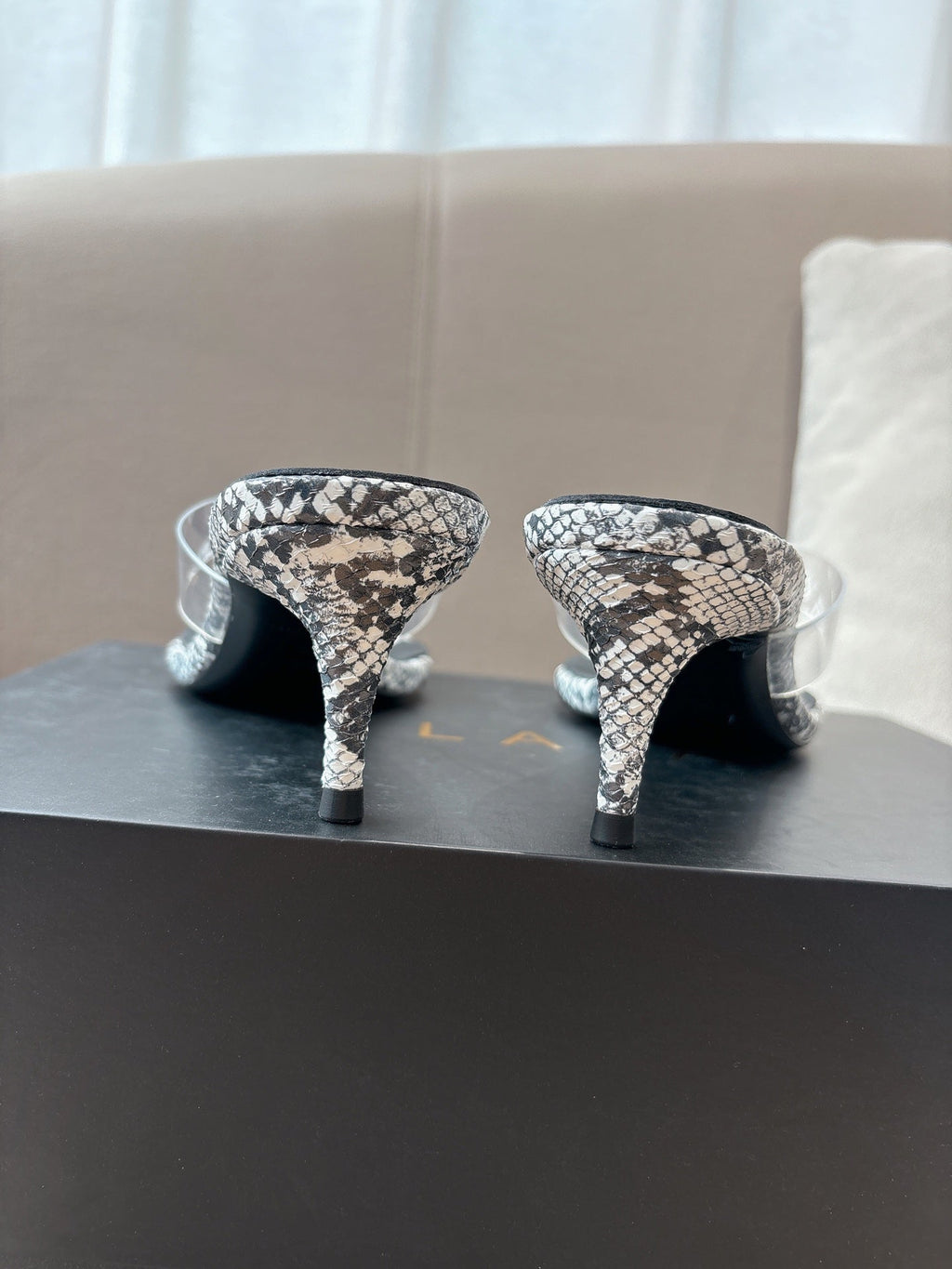 ALAIA HEELED THONG 25S 55 MM IN WHITE AND BLACK LAMBSKIN SNAKE-EMBOSSED WITH CLEAR STRAP