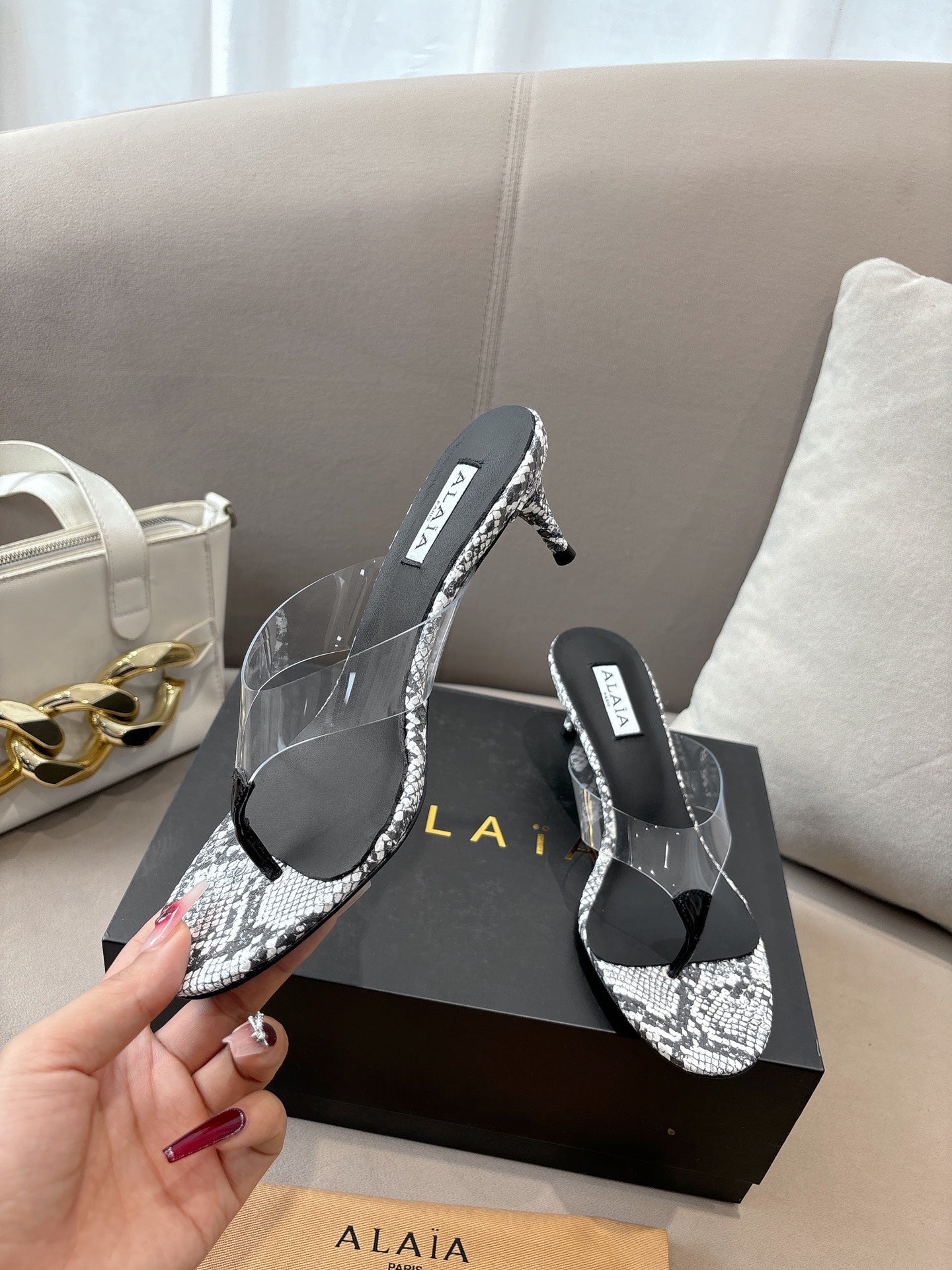 ALAIA HEELED THONG 25S 55 MM IN WHITE AND BLACK LAMBSKIN SNAKE-EMBOSSED WITH CLEAR STRAP