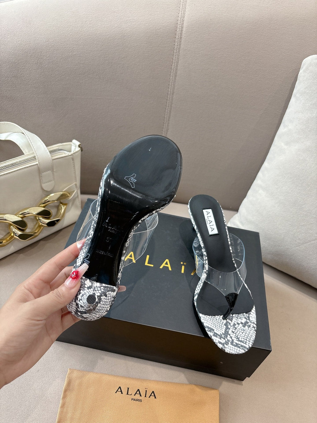 ALAIA HEELED THONG 25S 55 MM IN WHITE AND BLACK LAMBSKIN SNAKE-EMBOSSED WITH CLEAR STRAP