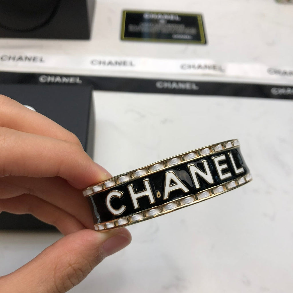 CHANEL 26S CHANEL LOGO BLACK ENAMEL STATEMENT CUFF BRACELET IN GOLD METAL 630834