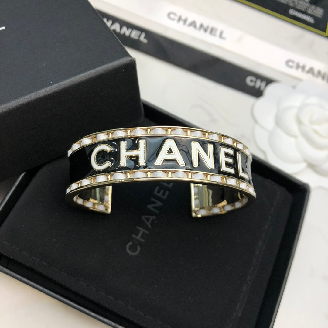 CHANEL 26S CHANEL LOGO BLACK ENAMEL STATEMENT CUFF BRACELET IN GOLD METAL 630834