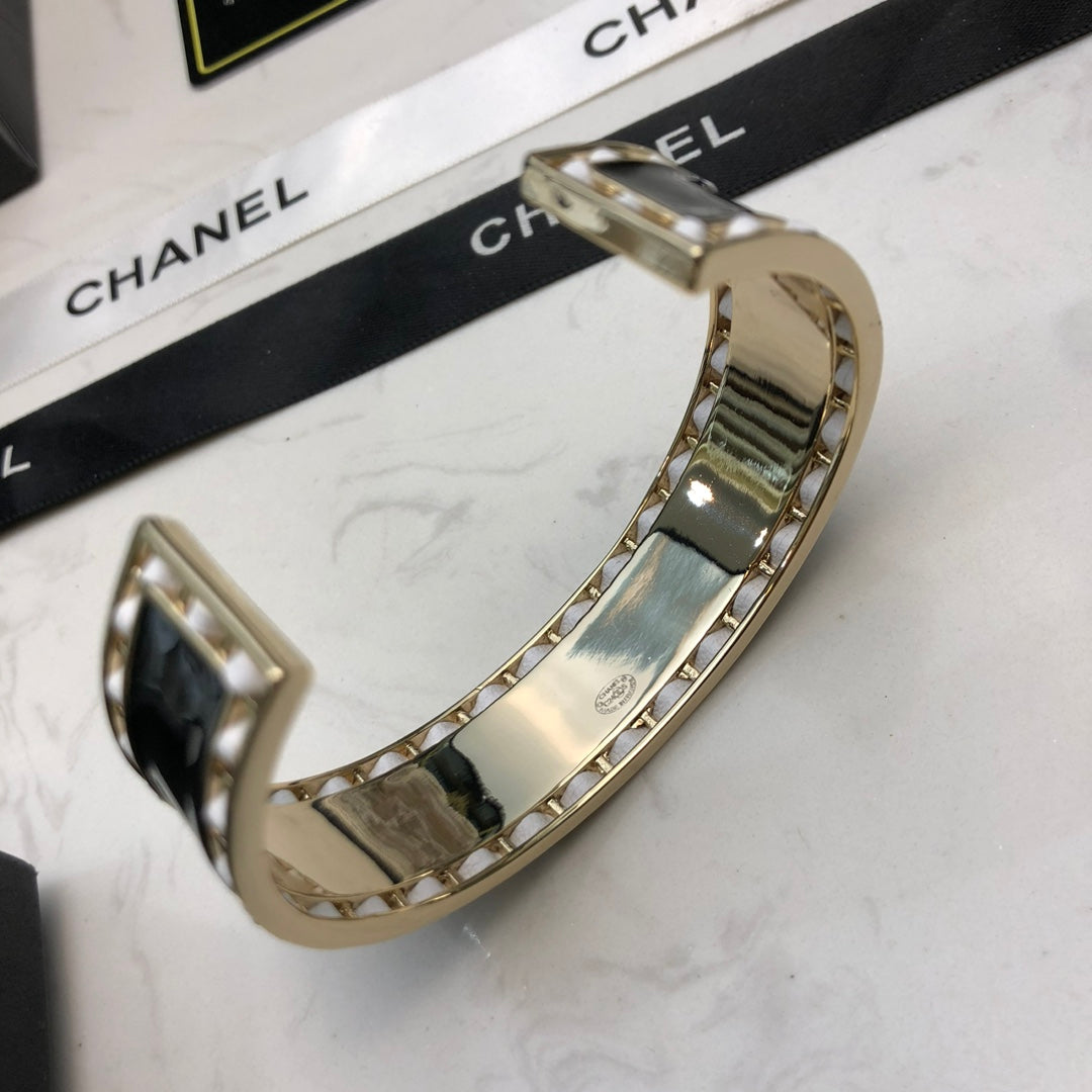 CHANEL 26S CHANEL LOGO BLACK ENAMEL STATEMENT CUFF BRACELET IN GOLD METAL 630834