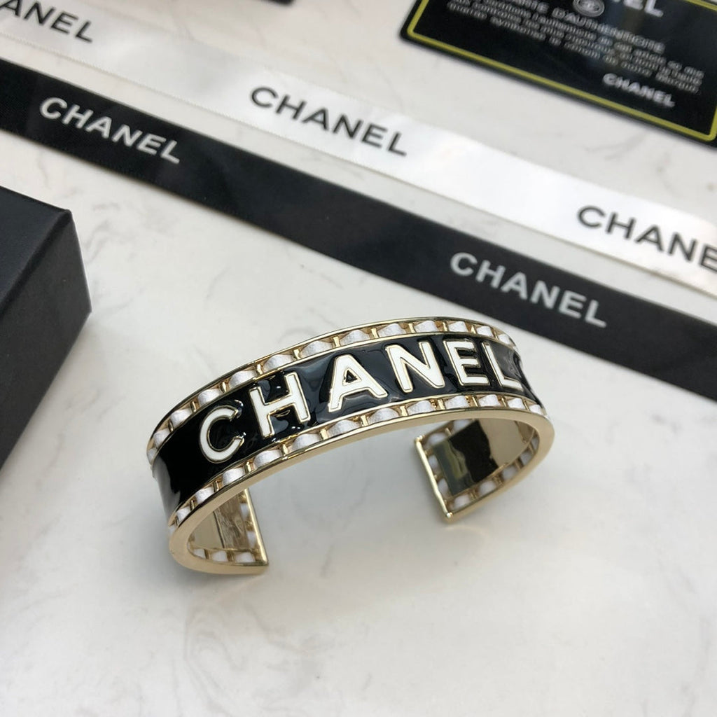 CHANEL 26S CHANEL LOGO BLACK ENAMEL STATEMENT CUFF BRACELET IN GOLD METAL 630834