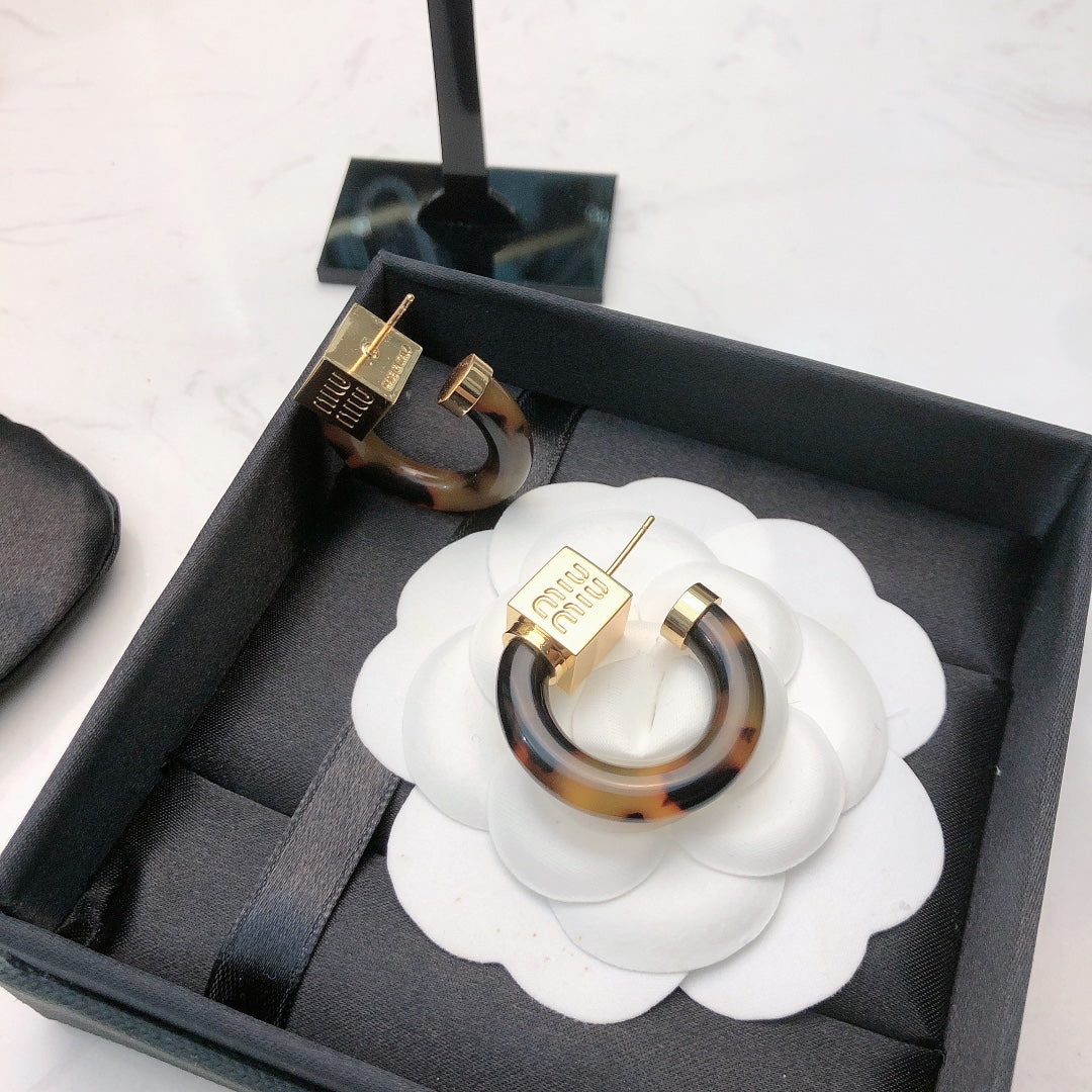 MIUMIU 26S TORTOISESHELL RESIN CURVED HOOP LOGO EARRINGS IN GOLD TONE METAL 615773