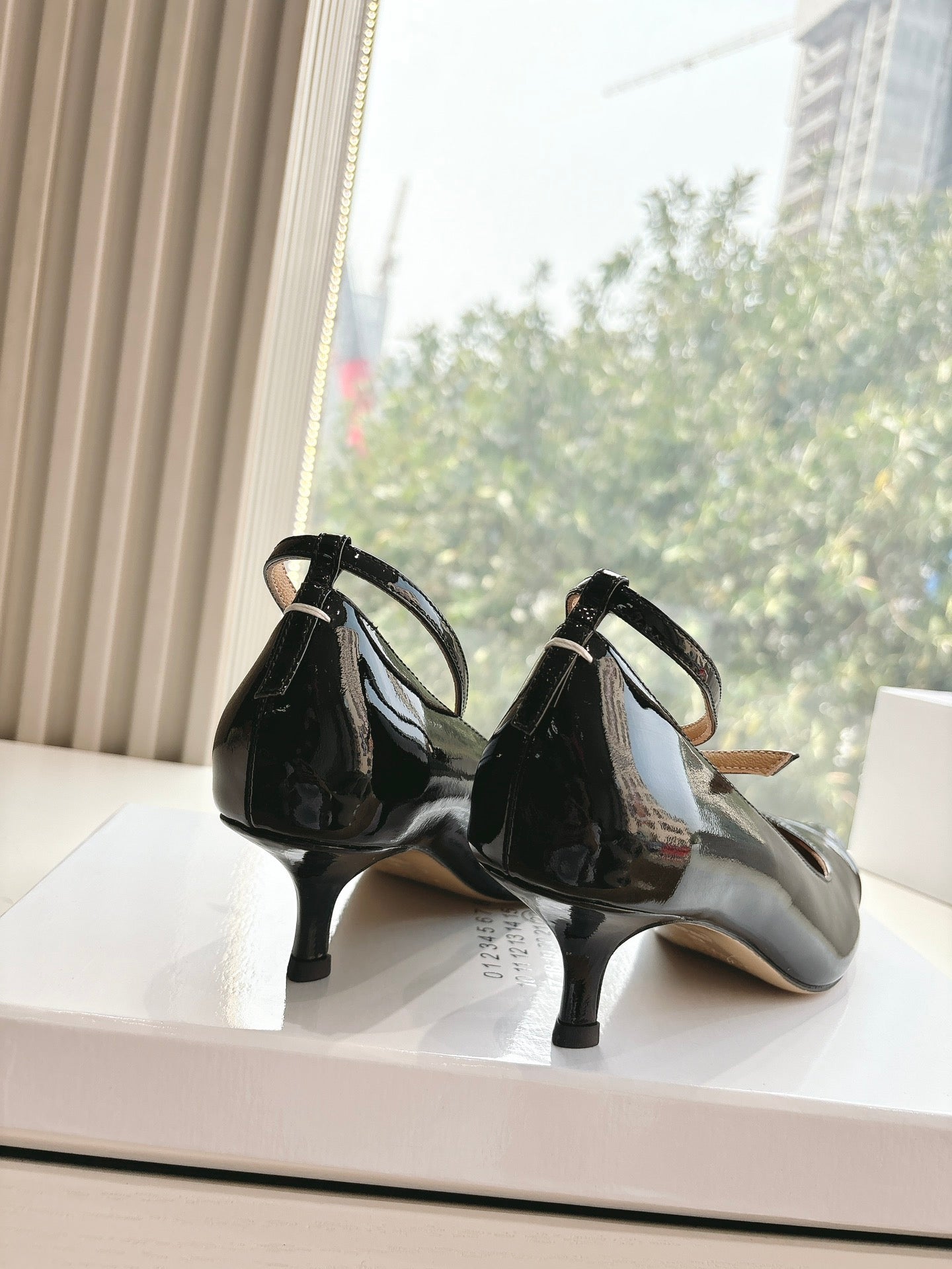 POINTED-TOE ANKLE STRAP PUMPS IN BLACK PATENT CALFSKIN
