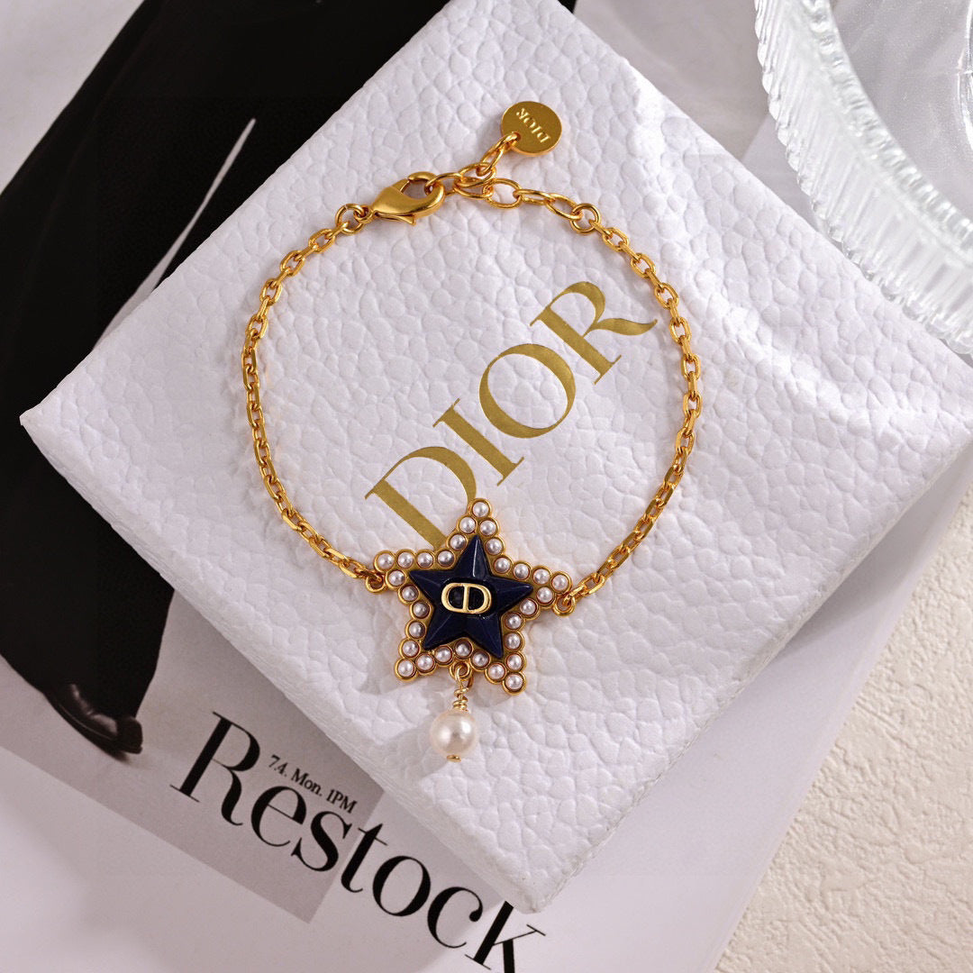 CD 26S PEARL STAR LOGO CHARM BRACELET IN GOLD TONE METAL