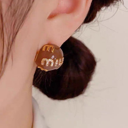 MIUMIU 26S MIU CRYSTAL LOGO STUD EARRINGS IN BROWN ENAMEL AND GOLD TONE METAL 633129