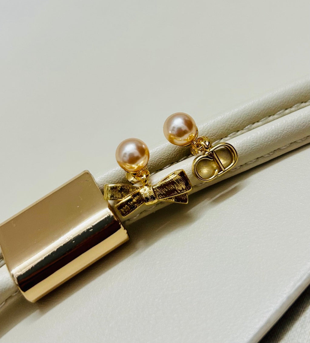 CD 26S PEARL BOW MISMATCH DROP EARRINGS IN GOLD TONE METAL 646611