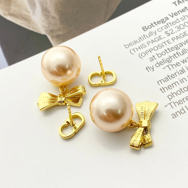 CD 26S PEARL BOW DROP EARRINGS IN GOLD TONE METAL 644484